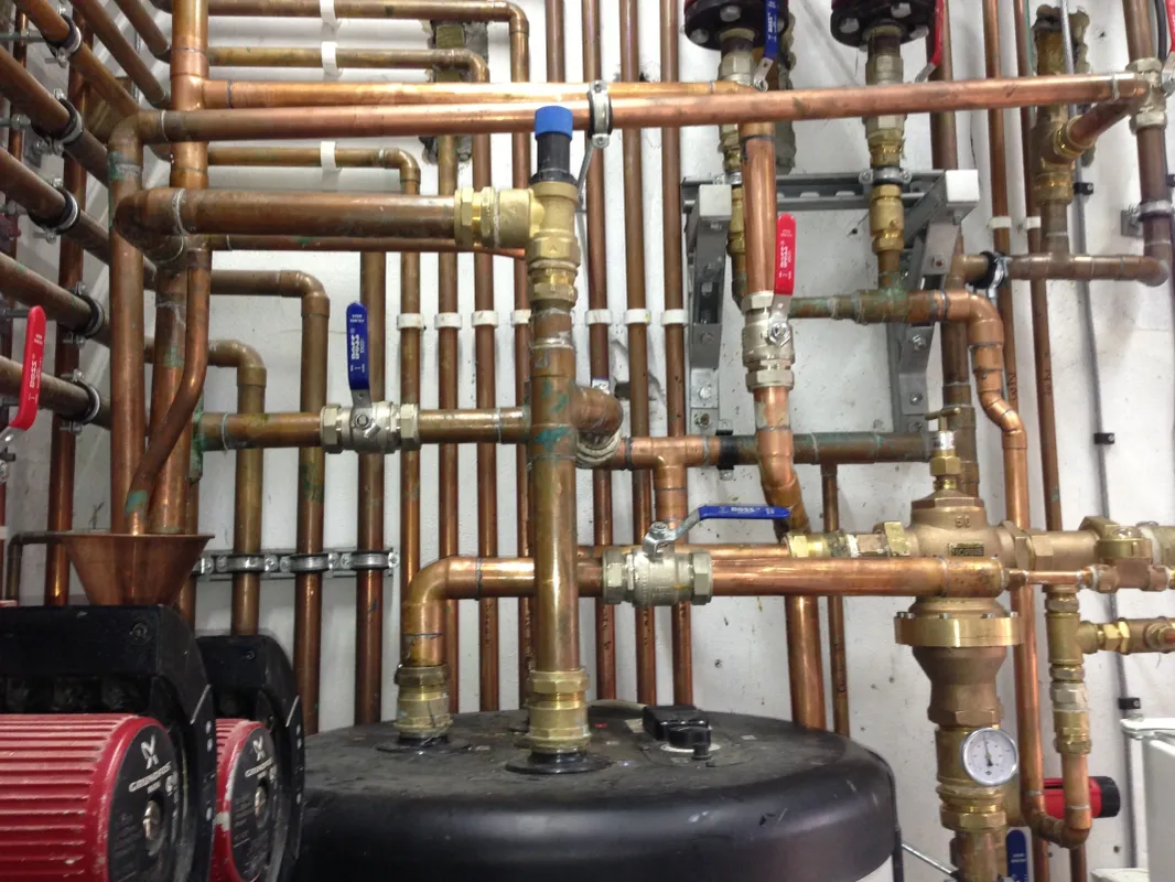 Completed heating manifold with red and blue flow and return valves feeding a new system