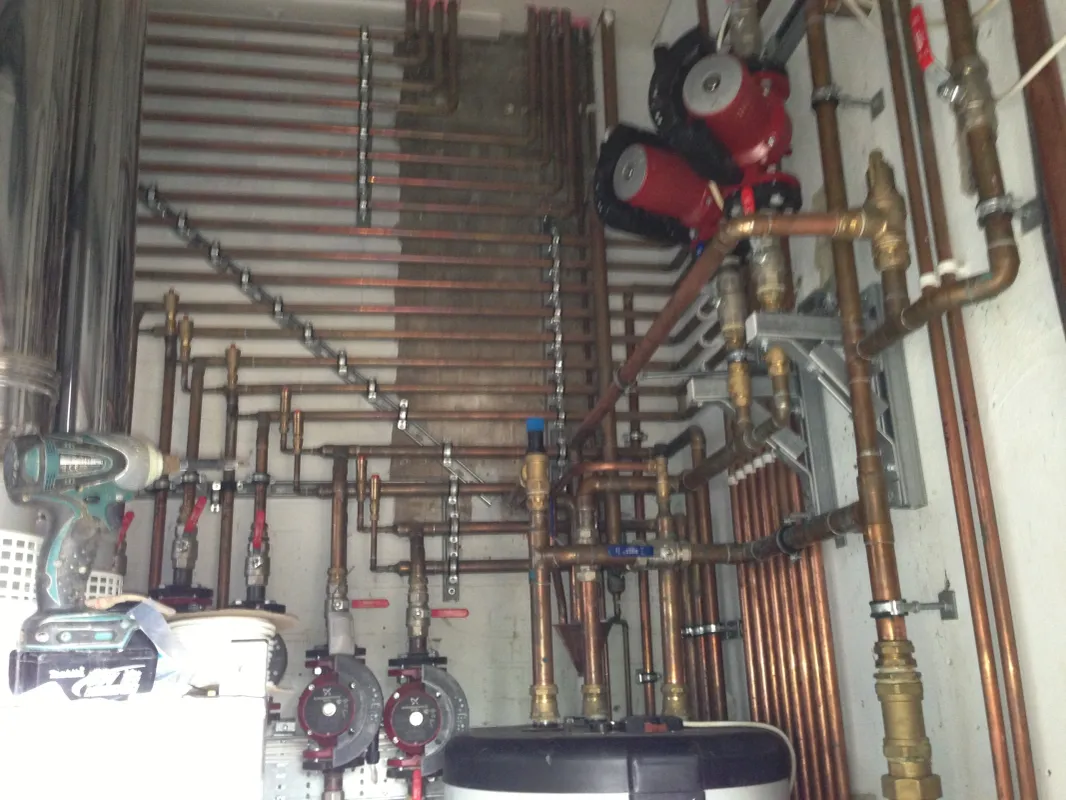 Plant room heating pipework and pumps part way through a central heating system upgrade