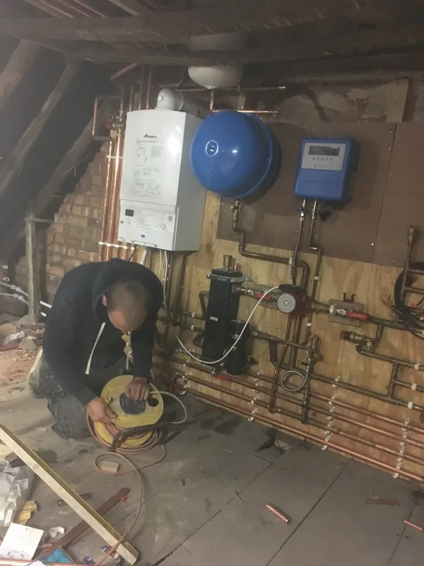 Gas Safe engineer fitting a Worcester system boiler with copper pipework in a loft conversion