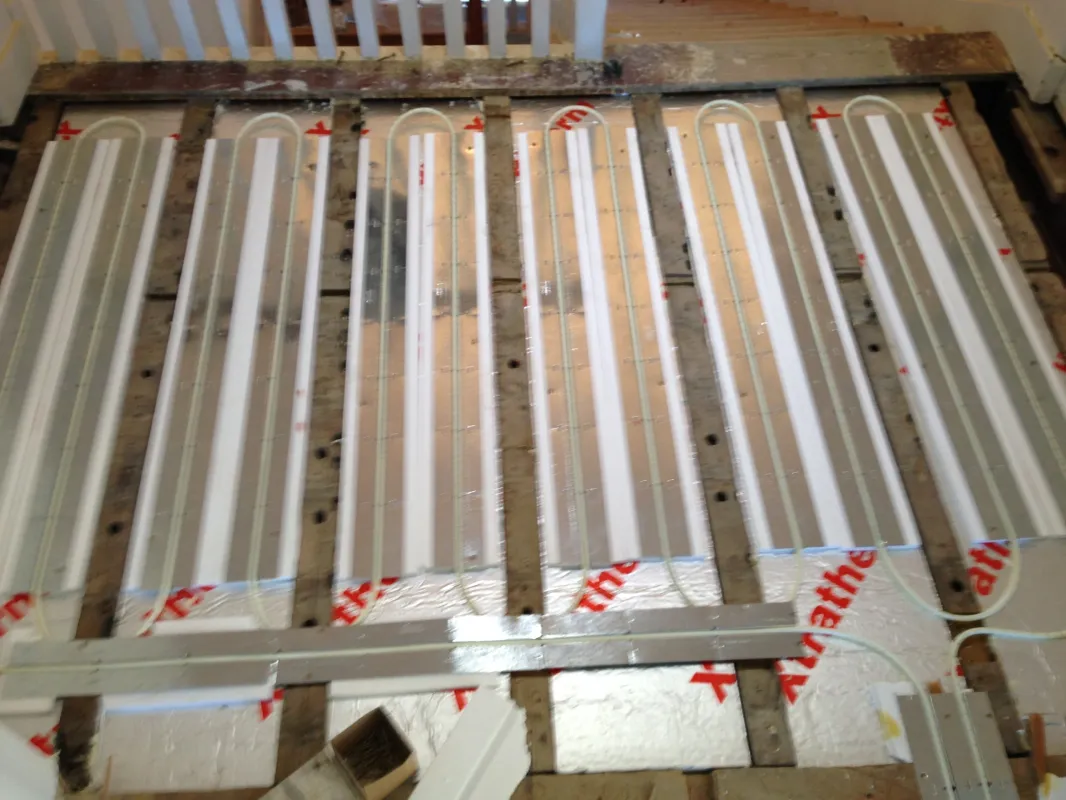 Underfloor heating loops fitted between floor joists with insulation before flooring goes down