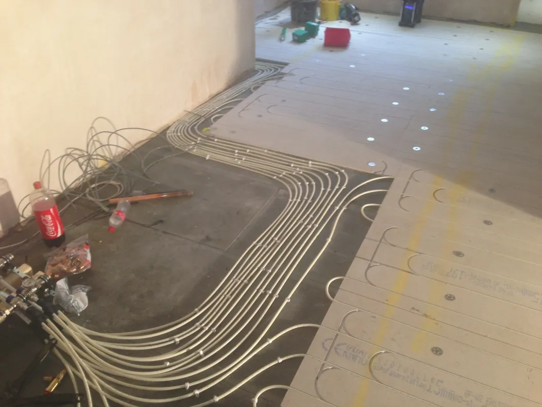 Underfloor heating pipe being laid into insulated floor panels during installation