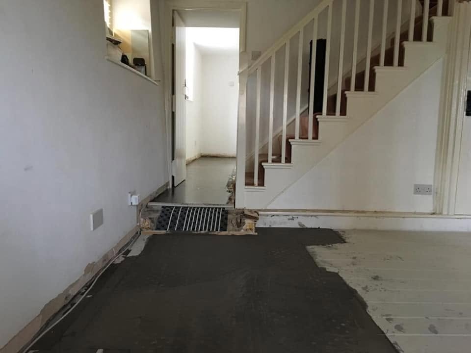 Heating pipework run beneath a hallway floor during a central heating installation