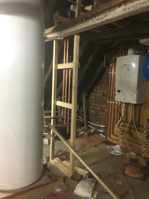 Large hot water cylinder installed in a loft alongside the boiler and expansion vessel