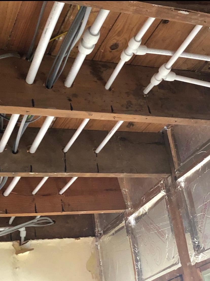 New central heating pipework installed between wooden floor joists